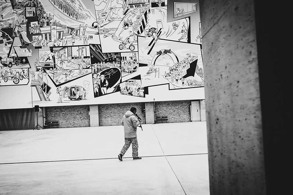 Red Bull Energy Station Oberwang: Mann vor Comic-Wand in Schwarzweiß.