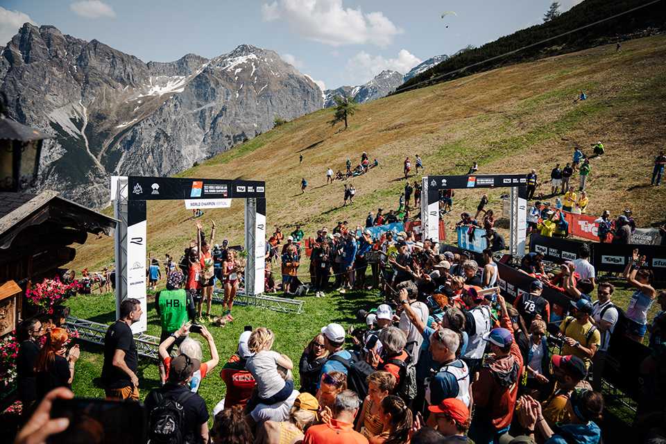 Siegerehrung der Trail Run WM in Innsbruck-Stubai. Läuferinnen feiern vor Bergkulisse.