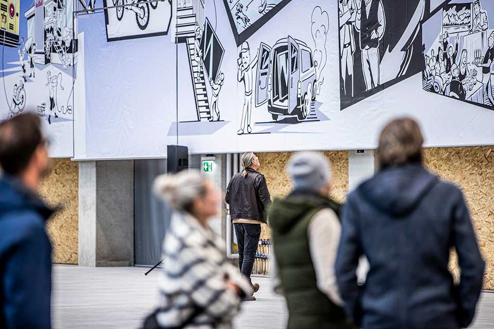 Besucher betrachten Red Bull Energy Station Department Oberwang Wandbild. Kunstausstellung.
